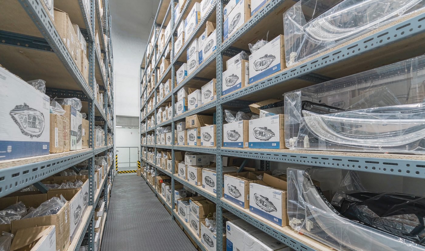 Organised auto parts warehouse in China with headlamps and body panels on racks